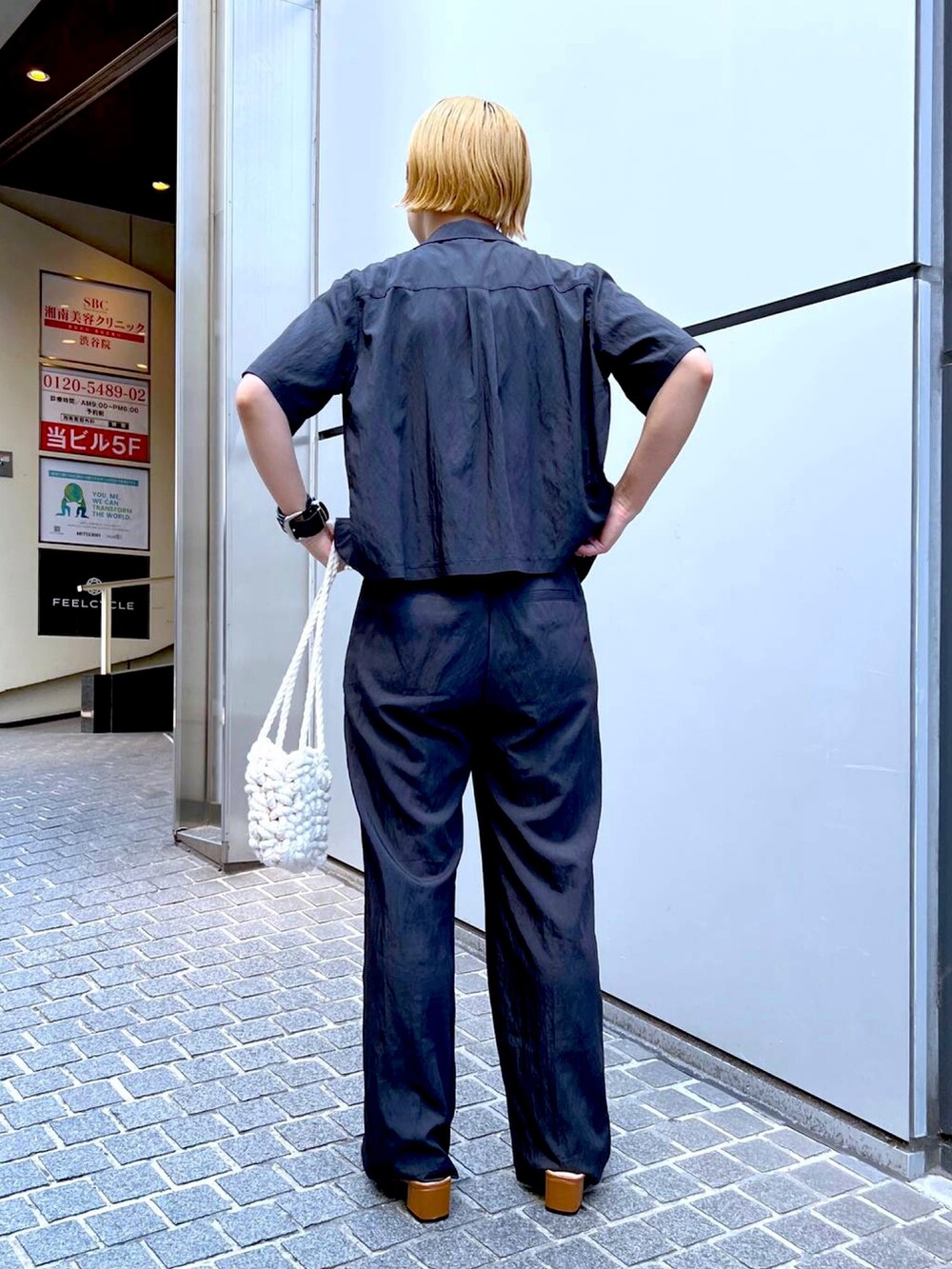 ブラック系のシャツ/ブラウス、ブラック系のスラックス、ベージュ系のTシャツ/カットソーを着用したレディースの夏コーディネートの2枚目の写真