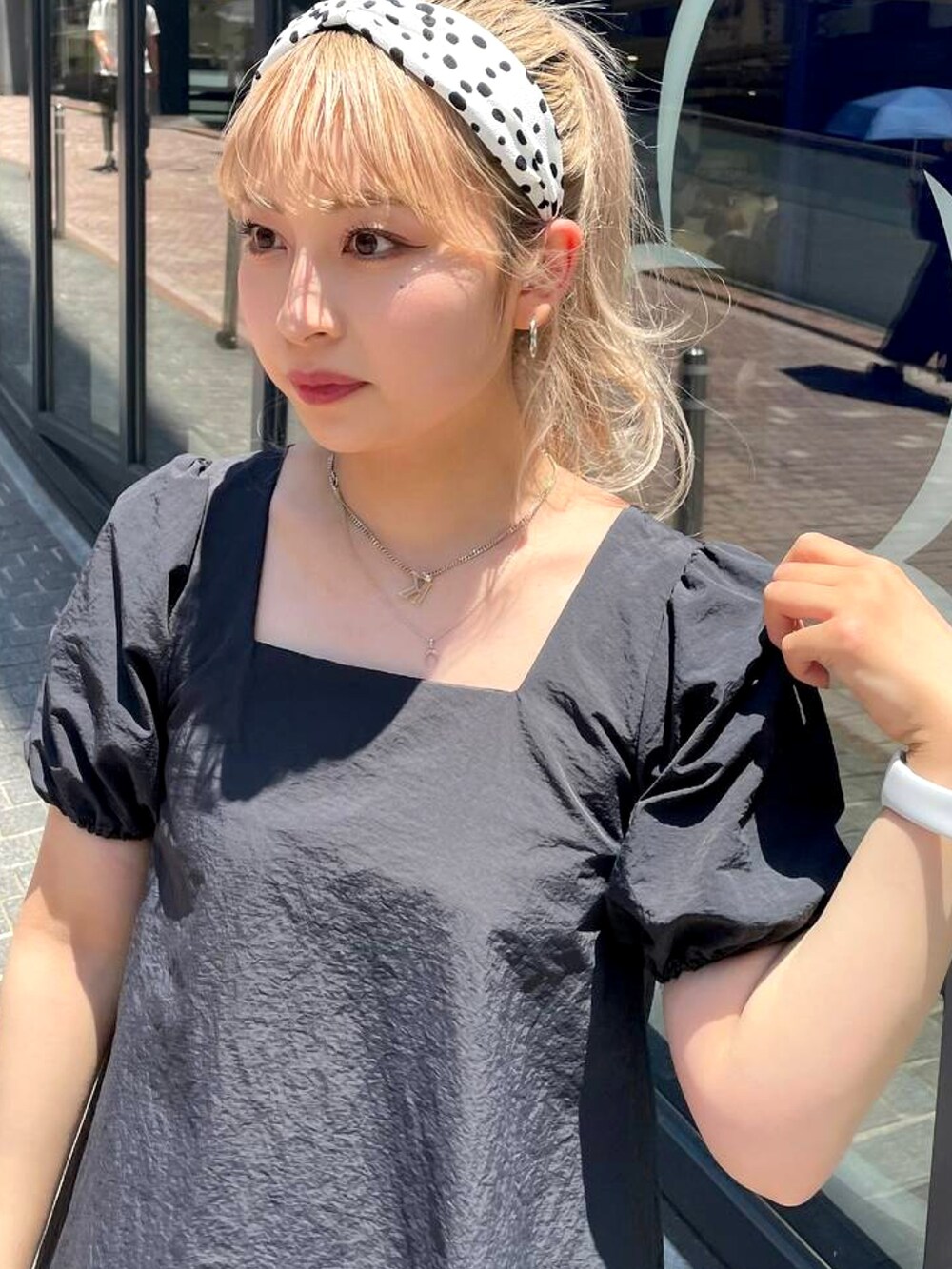 ブラック系のワンピース、ブルー系のデニムパンツ、ベージュ系のサンダルを着用したレディースの夏コーディネートの4枚目の写真