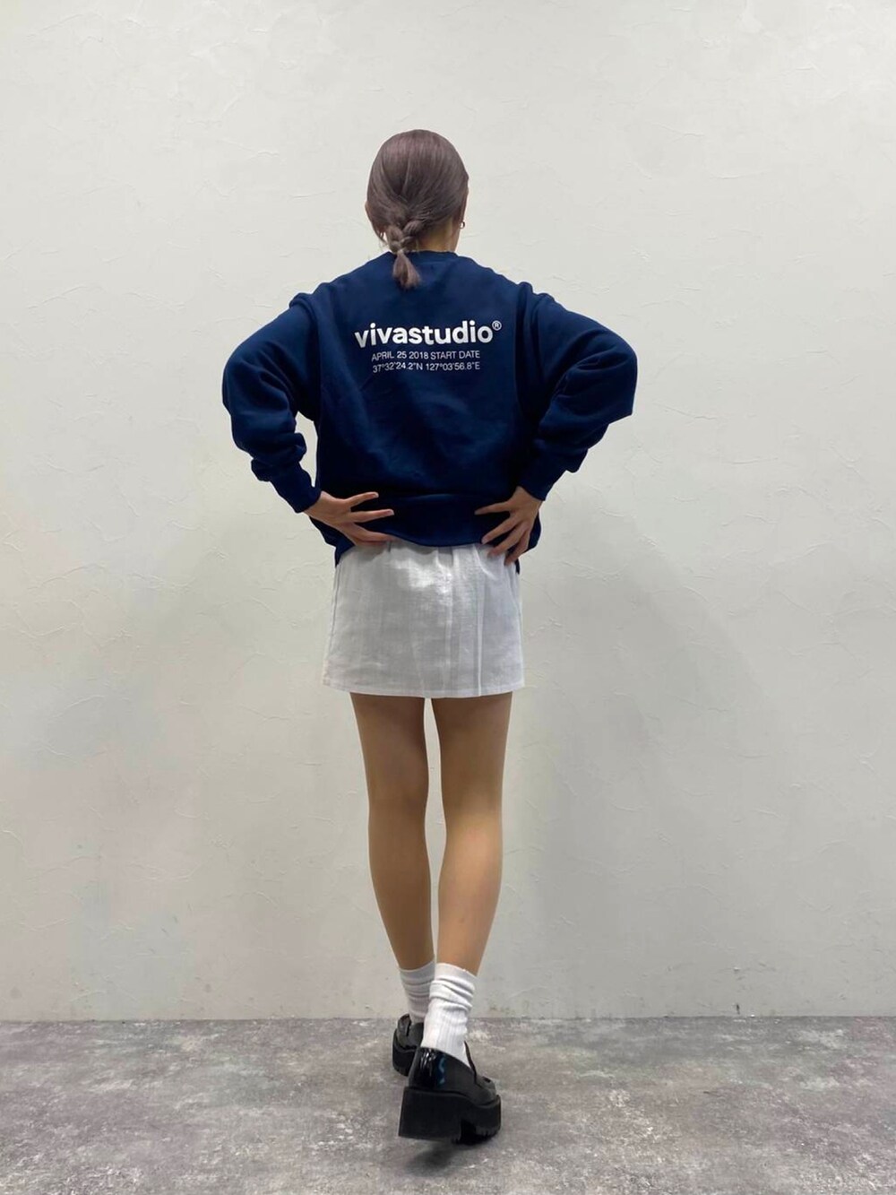 ブルー系のスウェット、ホワイト系のスカートを着用したレディースの秋コーディネートの2枚目の写真