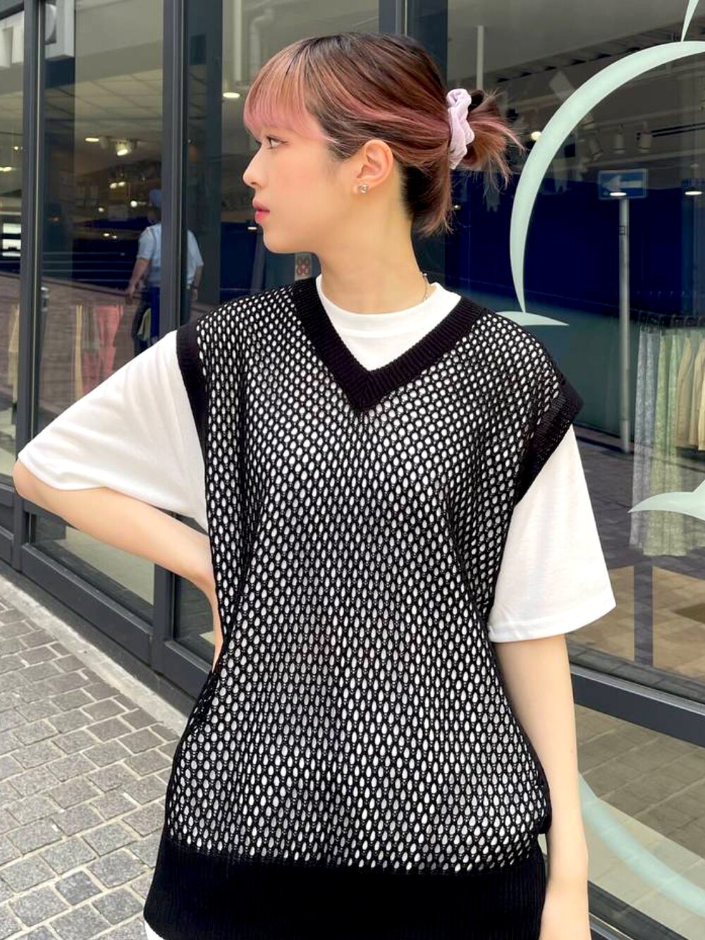 ブラック系のベスト、ブラック系のスラックスを着用したレディースの夏コーディネートの2枚目の写真