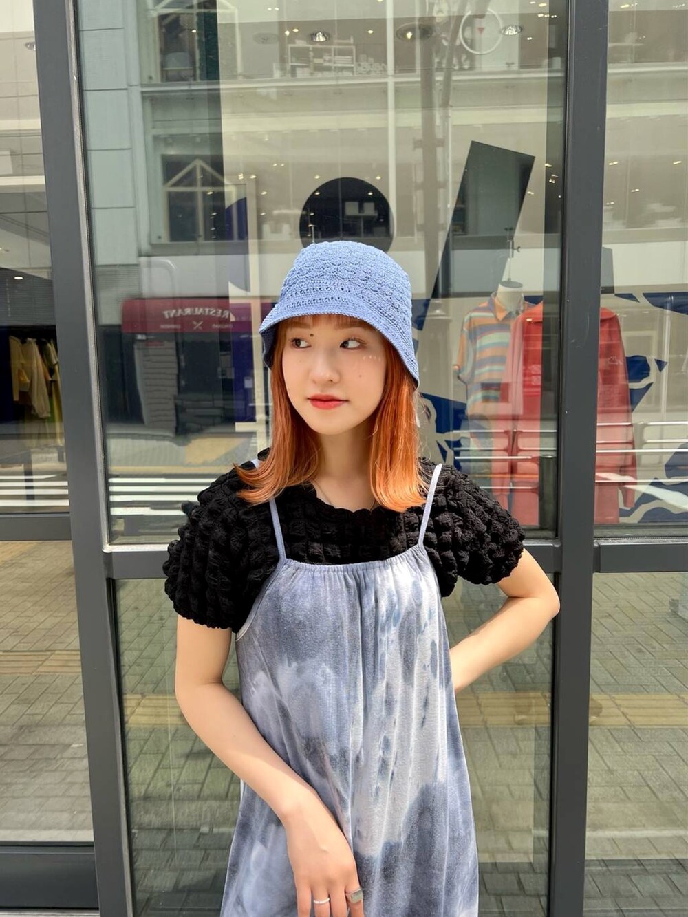 ブラック系のTシャツ/カットソー、ブルー系のワンピース、ブルー系のハットを着用したレディースの春コーディネートの2枚目の写真