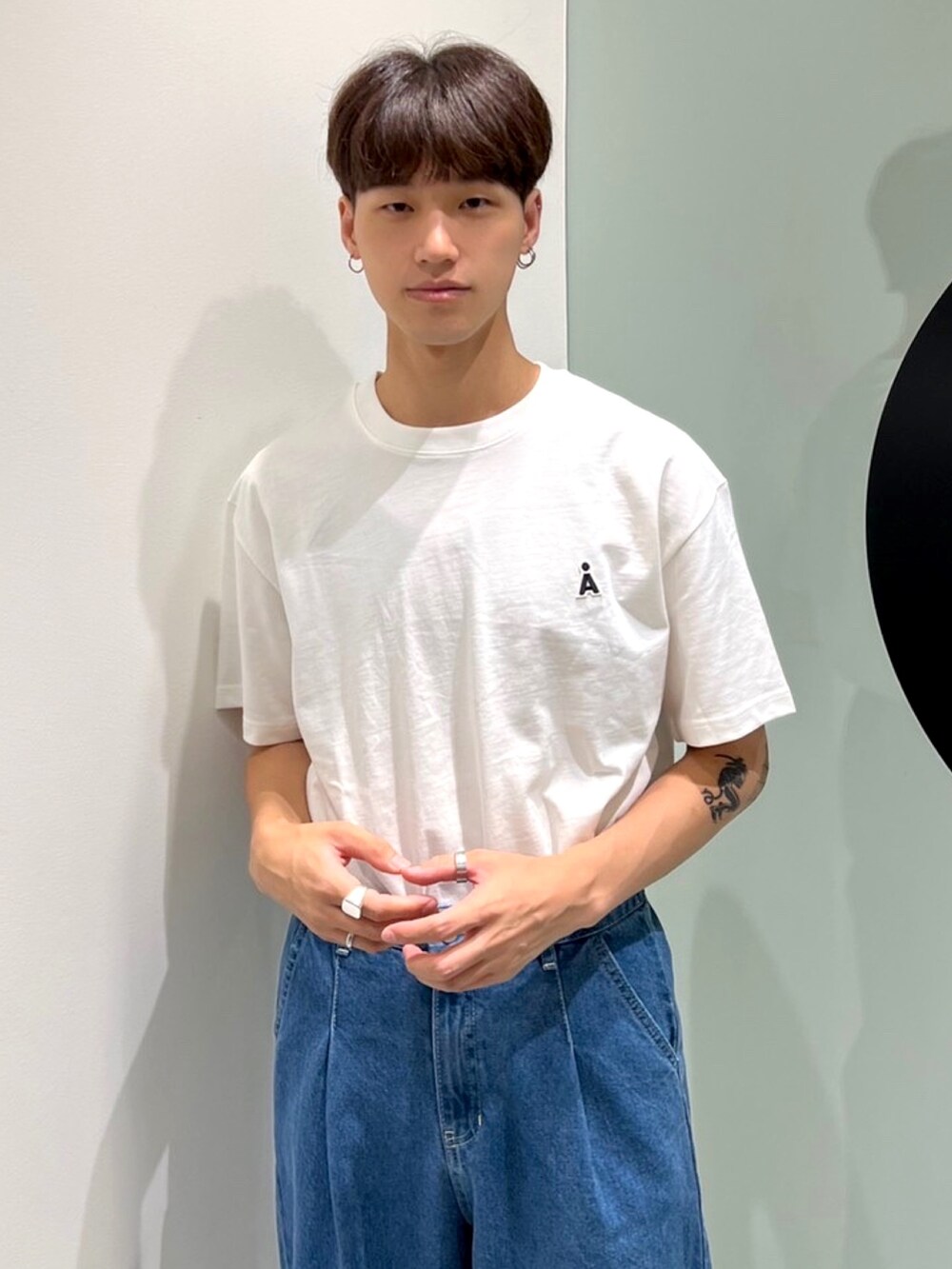 ベージュ系のTシャツ/カットソー、ブルー系のデニムパンツを着用したメンズの夏コーディネートの2枚目の写真