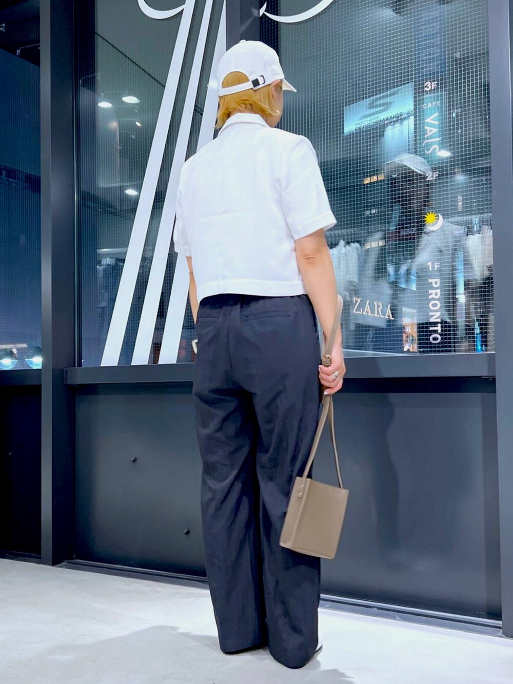 ベージュ系のテーラードジャケット、ベージュ系のTシャツ/カットソー、ブラック系のスラックスを着用したレディースの夏コーディネートの3枚目の写真