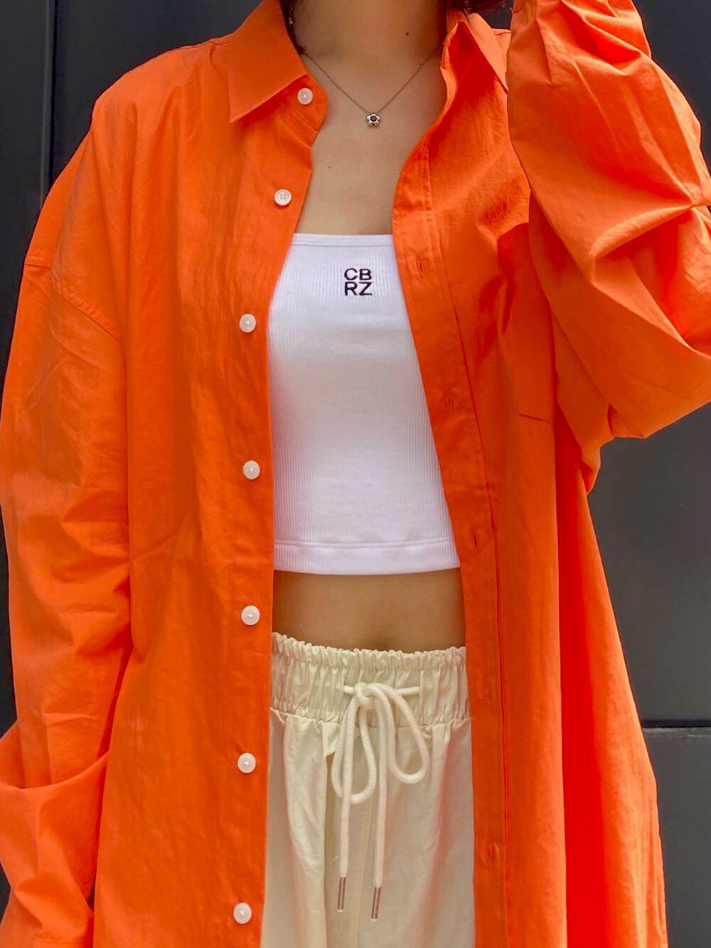 オレンジ系のシャツ/ブラウス、ベージュ系のその他パンツを着用したレディースの秋コーディネートの2枚目の写真