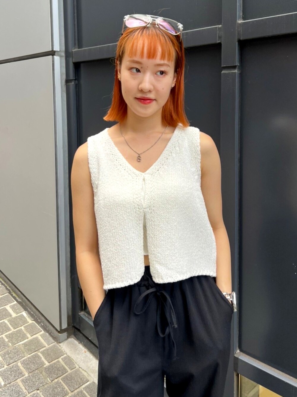 ベージュ系のベストを着用したレディースの夏コーディネートの2枚目の写真