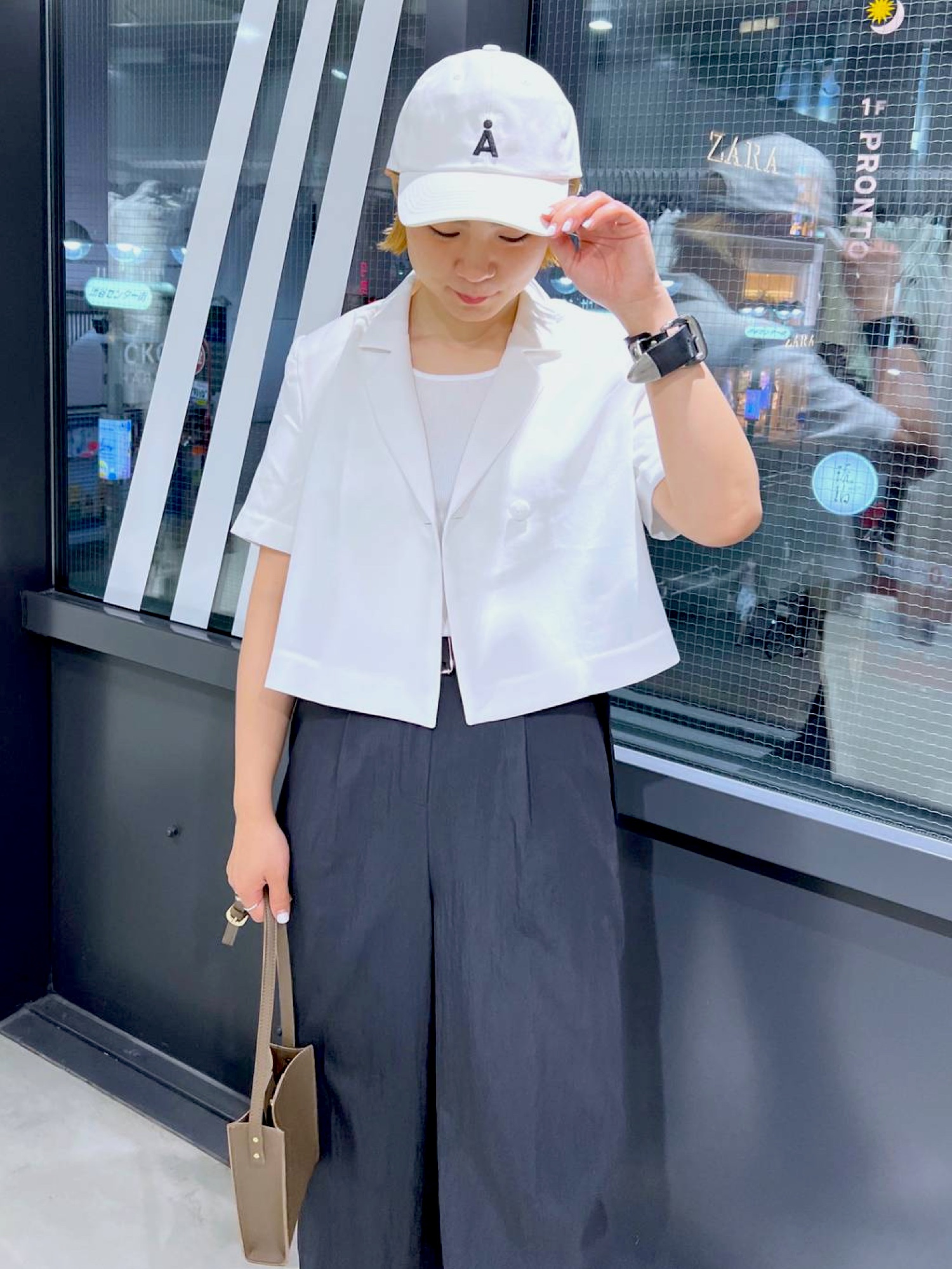 ベージュ系のテーラードジャケット、ベージュ系のTシャツ/カットソー、ブラック系のスラックスを着用したレディースの夏コーディネートの4枚目の写真