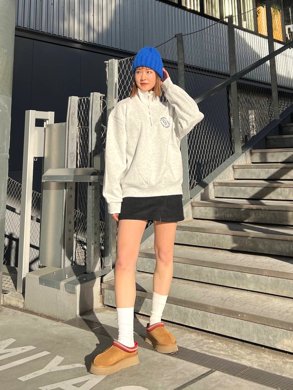 ベージュ系のダウンジャケット/コート、グレー系のスウェット、ブラック系のスカートを着用したレディースの冬コーディネートの2枚目の写真