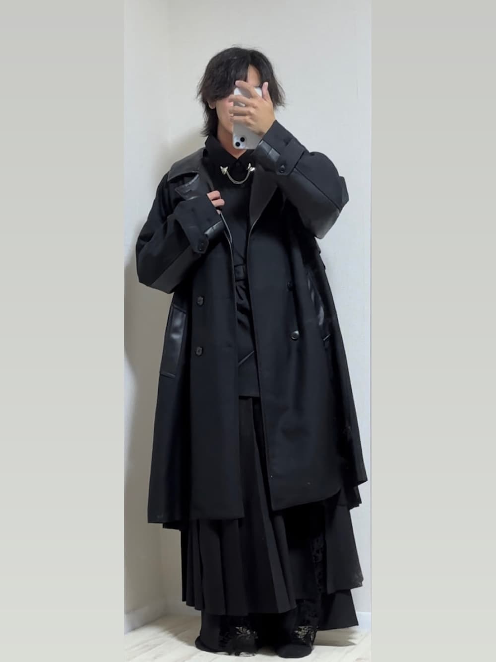 ブラック系のトレンチコート、ブラック系のスカート、ブラック系のその他パンツを着用したメンズの秋コーディネートの2枚目の写真