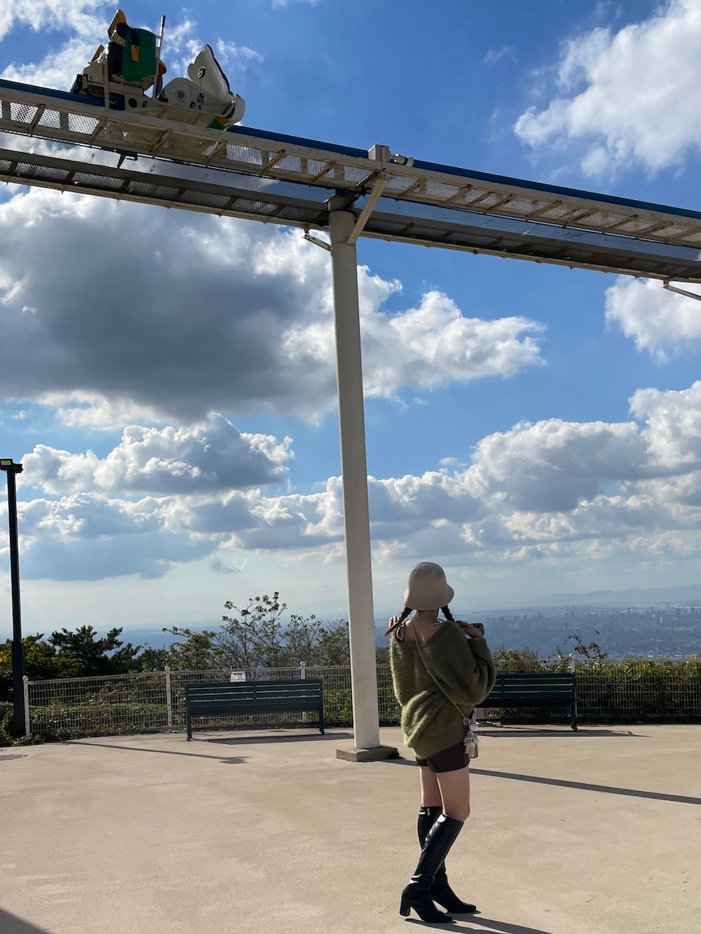 ブラック系のブーツ、グレー系のショルダーバッグ、グリーン系のカーディガン/ボレロを着用したレディースの秋コーディネートの3枚目の写真