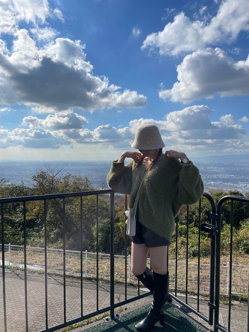 ブラック系のブーツ、グレー系のショルダーバッグ、グリーン系のカーディガン/ボレロを着用したレディースの秋コーディネートの2枚目の写真