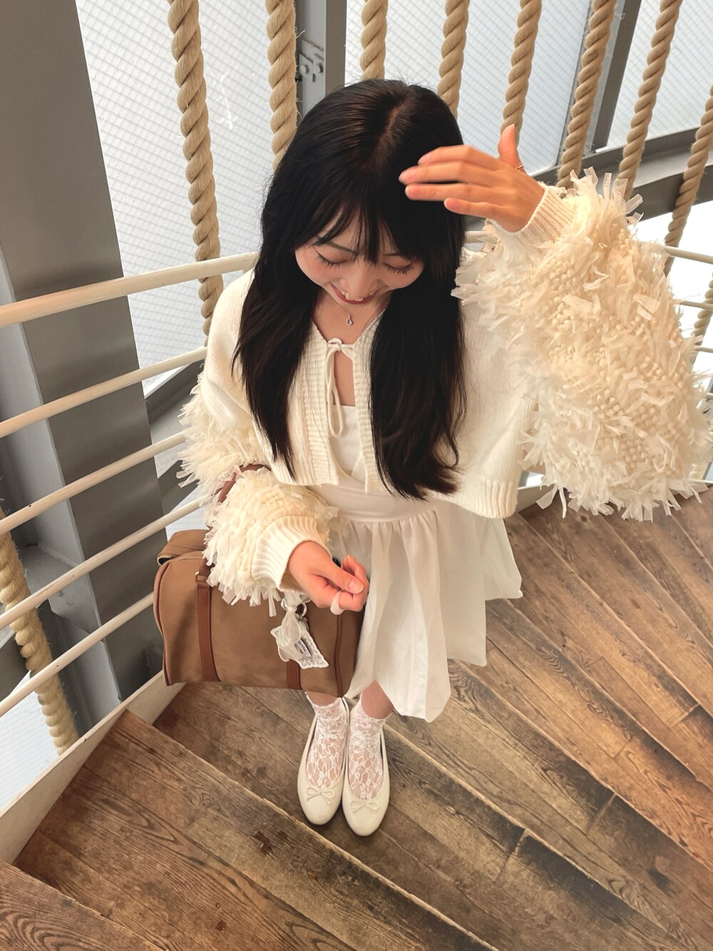 ホワイト系のカーディガン/ボレロ、ホワイト系のワンピース、ブラウン系のバッグを着用したレディースの秋コーディネートの4枚目の写真