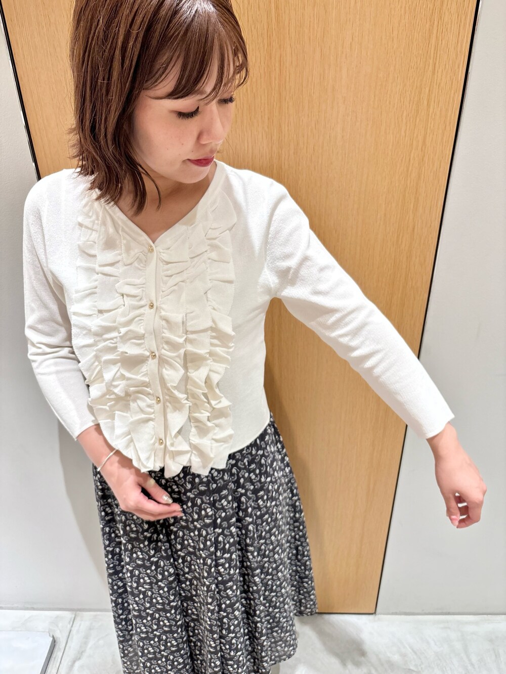 ブラック系のスカート、レッド系のハンドバッグ、ホワイト系のニット/セーターを着用したレディースの秋コーディネートの7枚目の写真