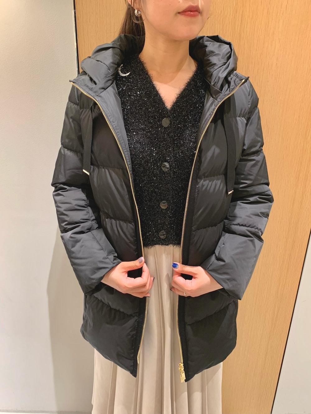 ホワイト系のスカート、ブラック系のダウンジャケット/コート、ブラック系のカーディガン/ボレロを着用したレディースの冬コーディネートの7枚目の写真