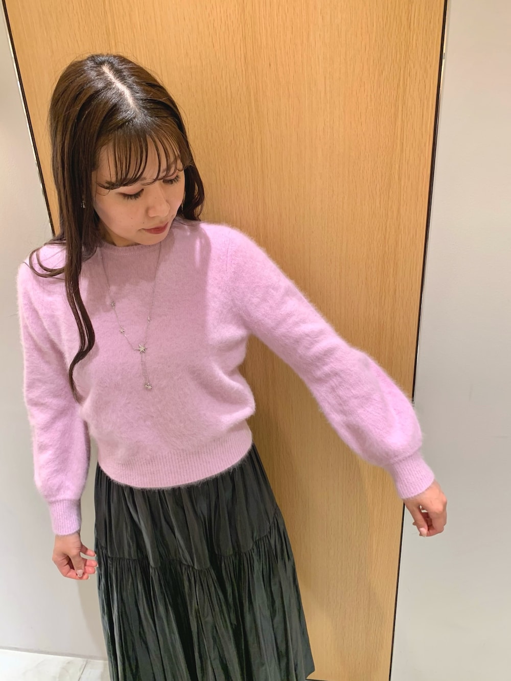 グレー系のハンドバッグ、ブラック系のスカート、パープル系のニット/セーターを着用したレディースの冬コーディネートの9枚目の写真