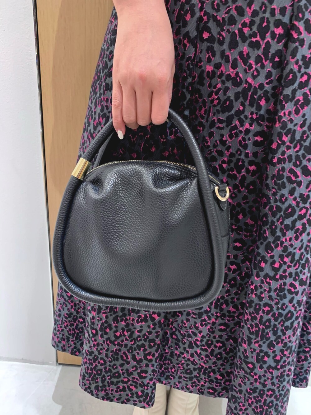 ピンク系のスカート、ブルー系のデニムジャケット、ブラック系のハンドバッグを着用したレディースの秋コーディネートの5枚目の写真