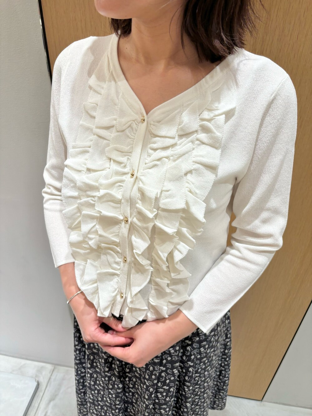 ブラック系のスカート、レッド系のハンドバッグ、ホワイト系のニット/セーターを着用したレディースの秋コーディネートの6枚目の写真