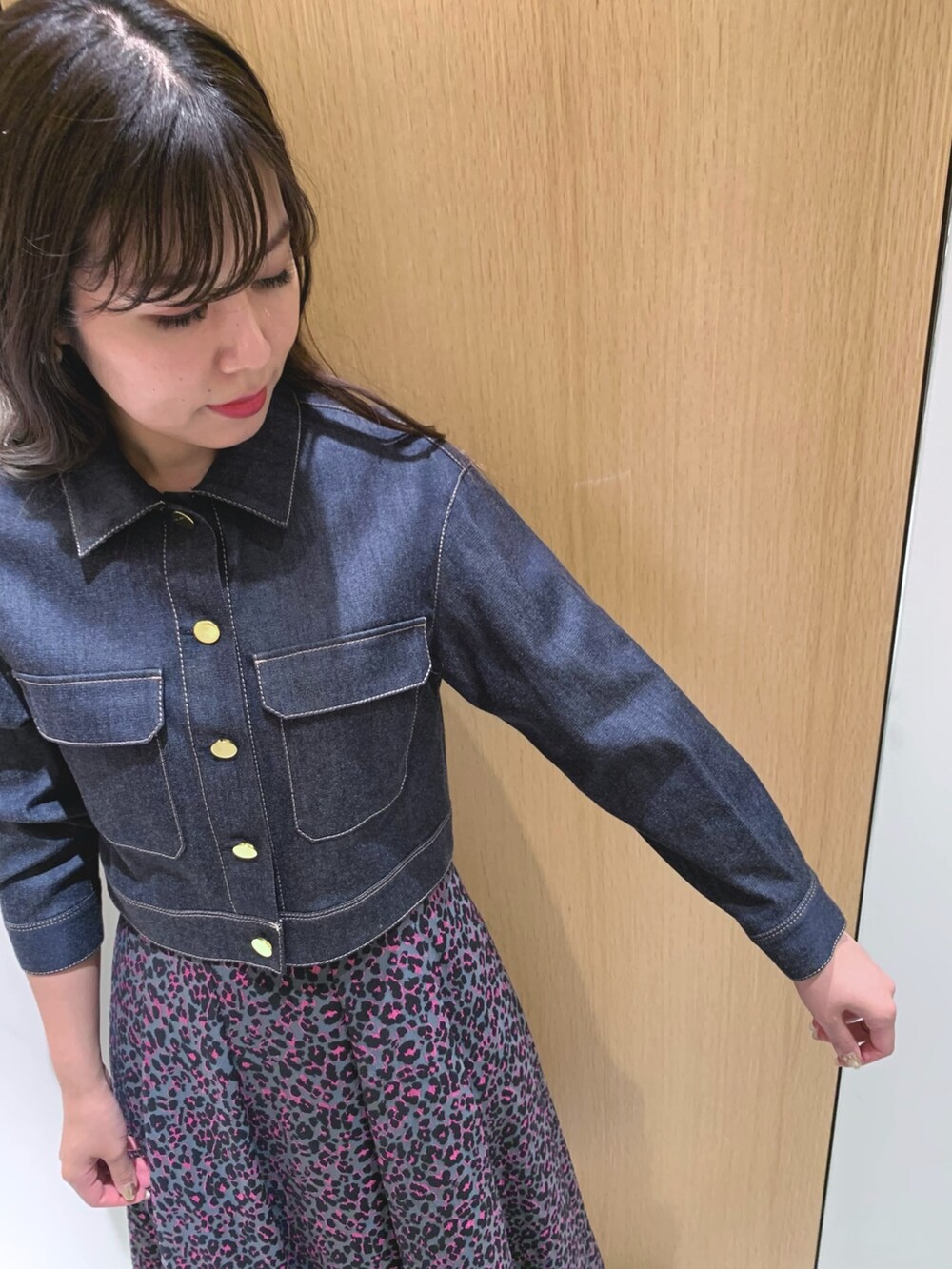 ピンク系のスカート、ブルー系のデニムジャケット、ブラック系のハンドバッグを着用したレディースの秋コーディネートの7枚目の写真