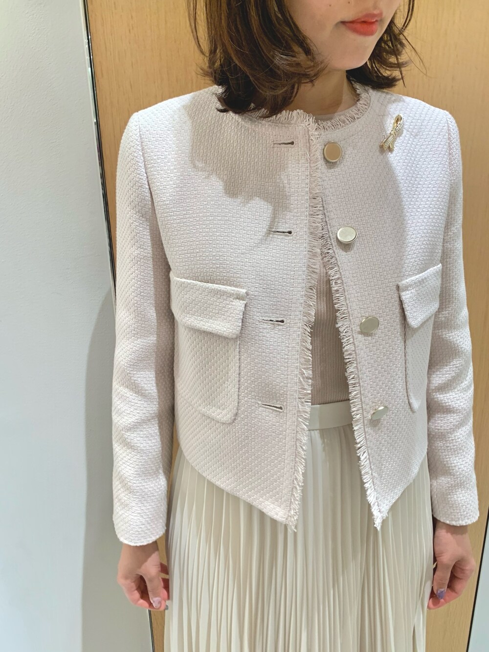 ホワイト系のスカート、ベージュ系のトートバッグ、ベージュ系のノーカラージャケットを着用したレディースの春コーディネートの8枚目の写真