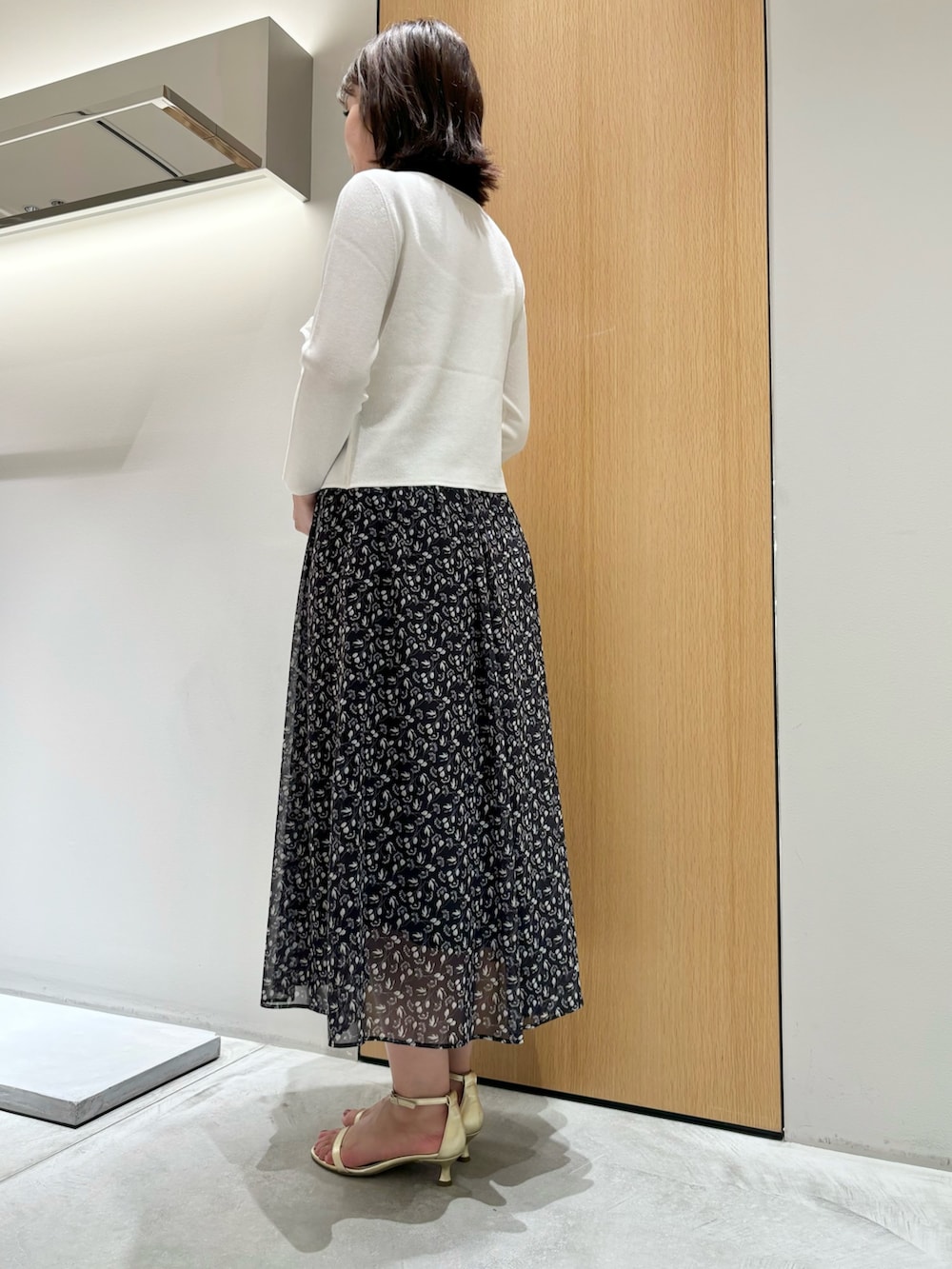 ブラック系のスカート、レッド系のハンドバッグ、ホワイト系のニット/セーターを着用したレディースの秋コーディネートの8枚目の写真