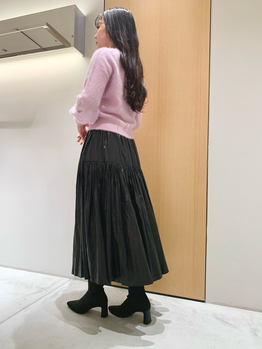 グレー系のハンドバッグ、ブラック系のスカート、パープル系のニット/セーターを着用したレディースの冬コーディネートの6枚目の写真