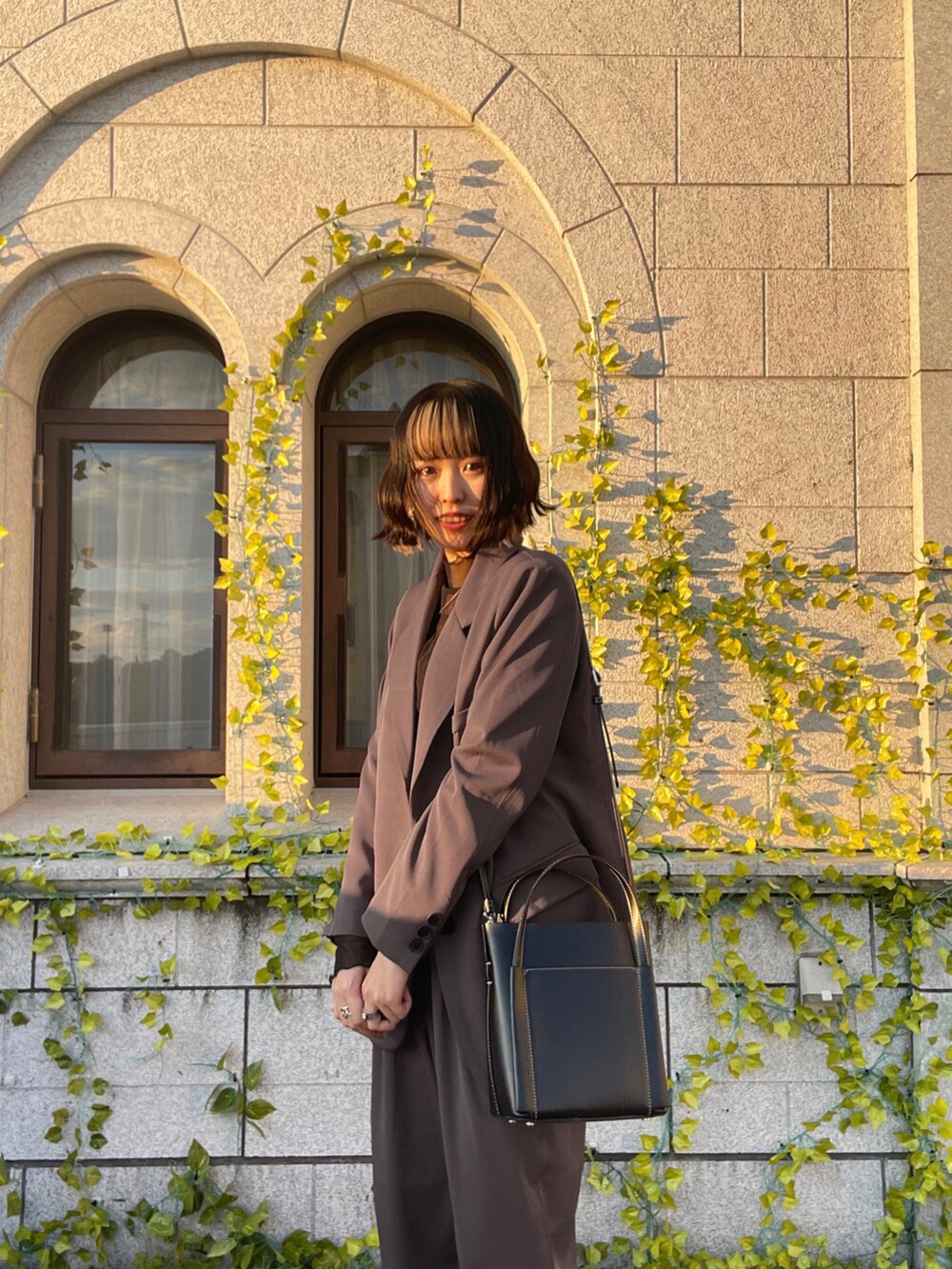 ブラック系のショルダーバッグ、パープル系のジャケット/アウター、ブラック系のトップスを着用したレディースの冬コーディネートの4枚目の写真