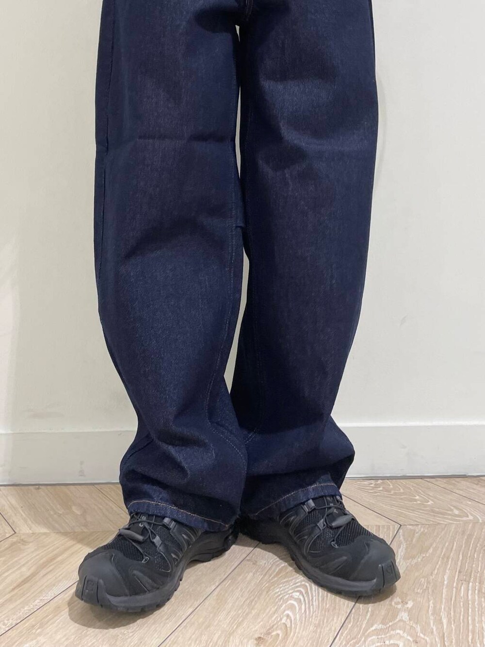 ホワイト系のキャミソール、ブラック系のボストンバッグ、ブルー系のデニムパンツを着用したレディースの秋コーディネートの4枚目の写真