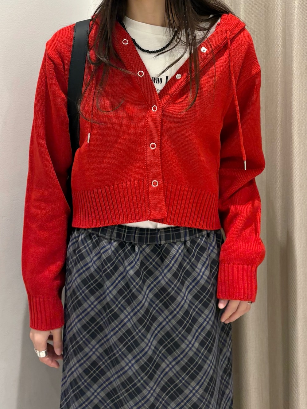 ブルー系のスカート、ホワイト系のTシャツ/カットソー、レッド系のニット/セーターを着用したレディースの秋コーディネートの4枚目の写真