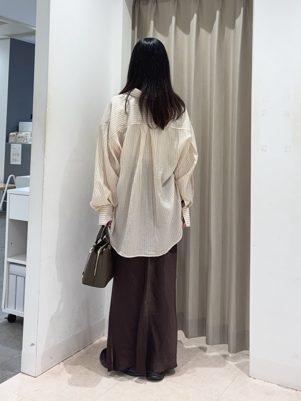 ブラウン系のスカート、ベージュ系のシャツ/ブラウス、ベージュ系のTシャツ/カットソーを着用したレディースの春コーディネートの2枚目の写真