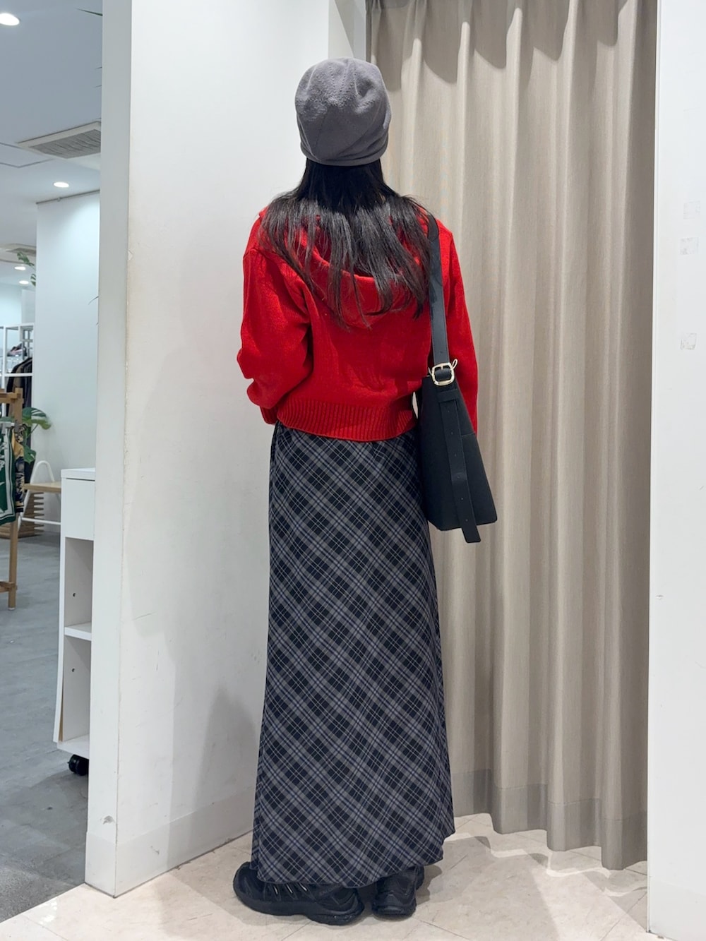 ブルー系のスカート、ホワイト系のTシャツ/カットソー、レッド系のニット/セーターを着用したレディースの秋コーディネートの3枚目の写真