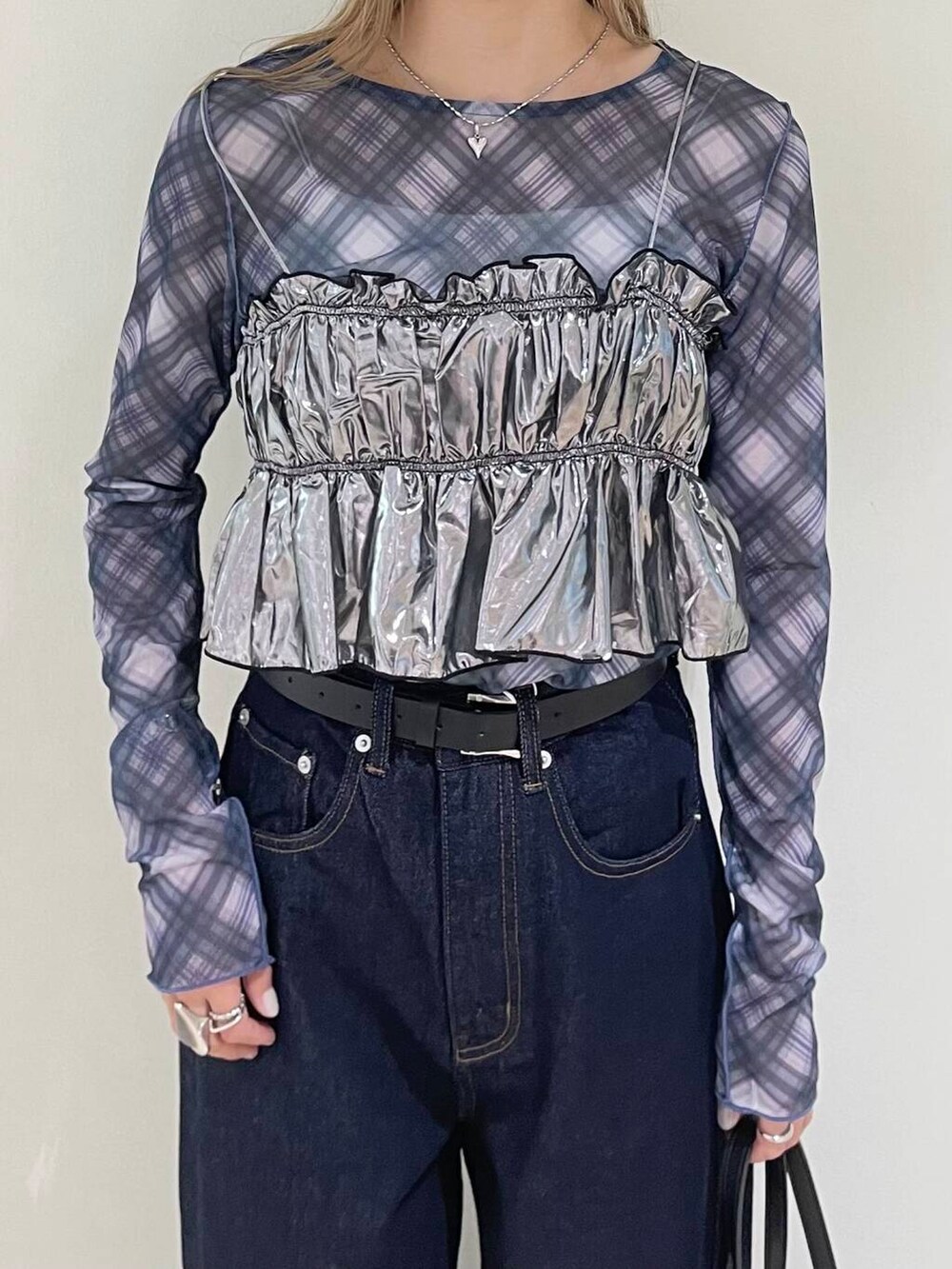 ホワイト系のキャミソール、ブラック系のボストンバッグ、ブルー系のデニムパンツを着用したレディースの秋コーディネートの3枚目の写真