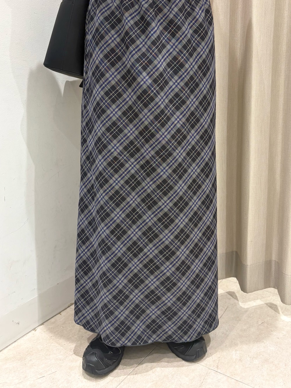 ブルー系のスカート、ホワイト系のTシャツ/カットソー、レッド系のニット/セーターを着用したレディースの秋コーディネートの5枚目の写真