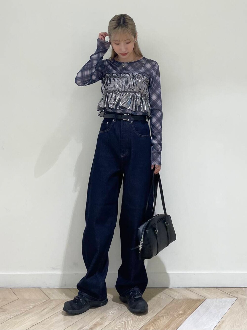ホワイト系のキャミソール、ブラック系のボストンバッグ、ブルー系のデニムパンツを着用したレディースの秋コーディネートの2枚目の写真