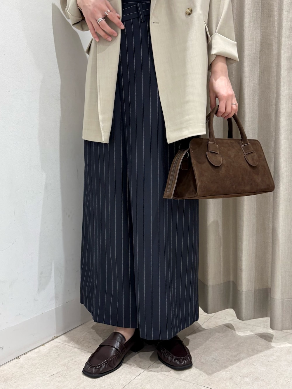 ブラック系のキャミソール、ベージュ系のその他アウター、ブラウン系のボストンバッグを着用したレディースの春コーディネートの4枚目の写真