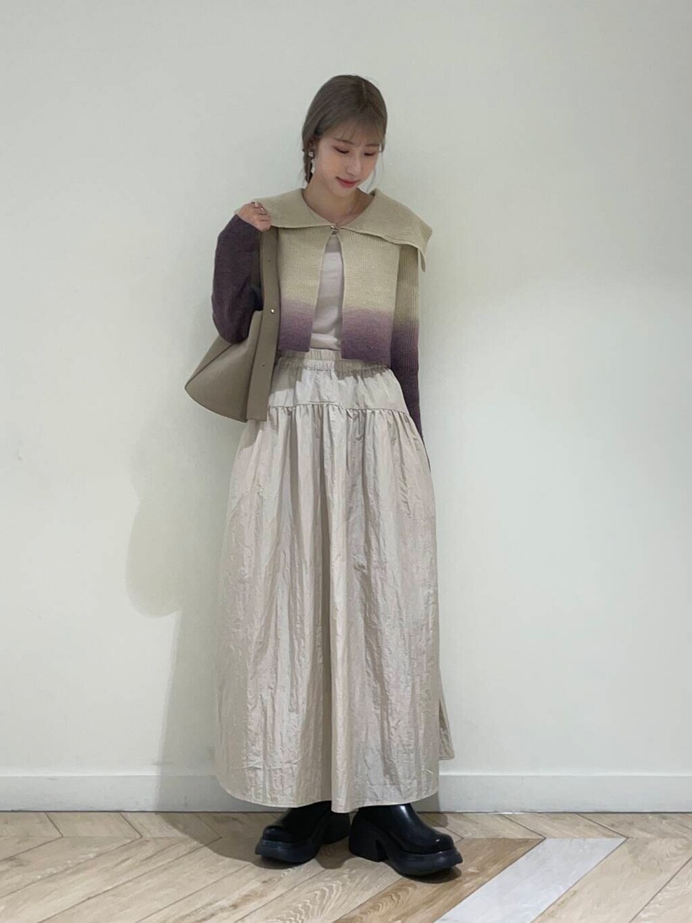 ベージュ系のキャミソール、ブラウン系のニット/セーター、ベージュ系のハンドバッグを着用したレディースの秋コーディネートの2枚目の写真