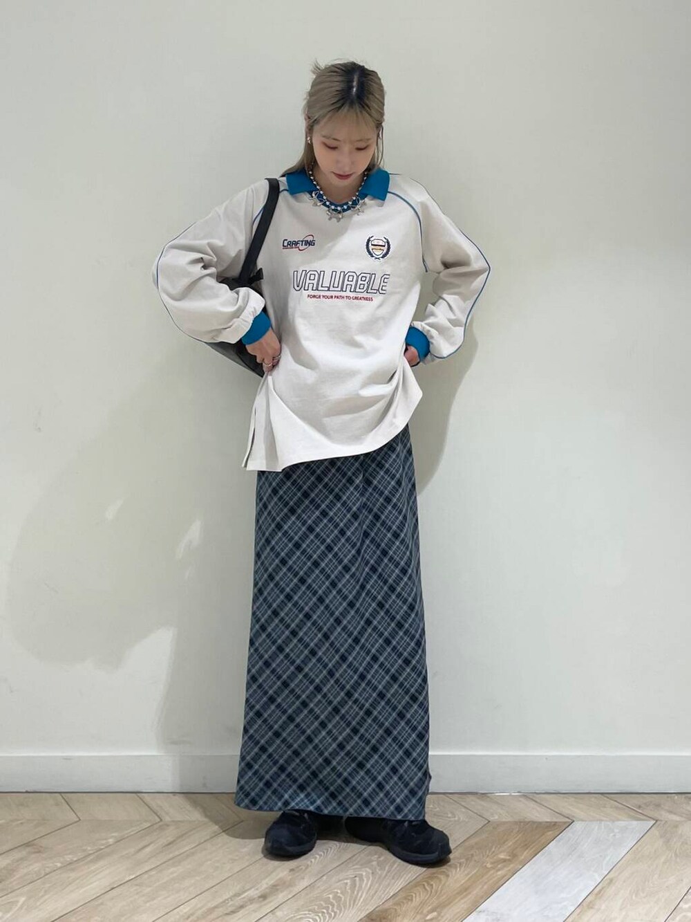 ブラック系のハンドバッグ、グレー系のスカート、ブルー系のTシャツ/カットソーを着用したレディースの秋コーディネートの2枚目の写真