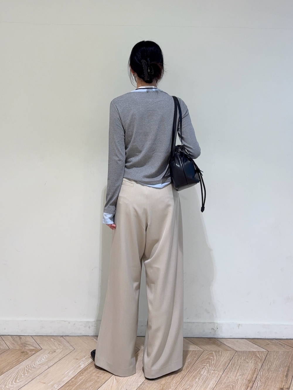 グレー系のTシャツ/カットソー、ベージュ系のスラックス、ブラック系のショルダーバッグを着用したレディースの春コーディネートの2枚目の写真