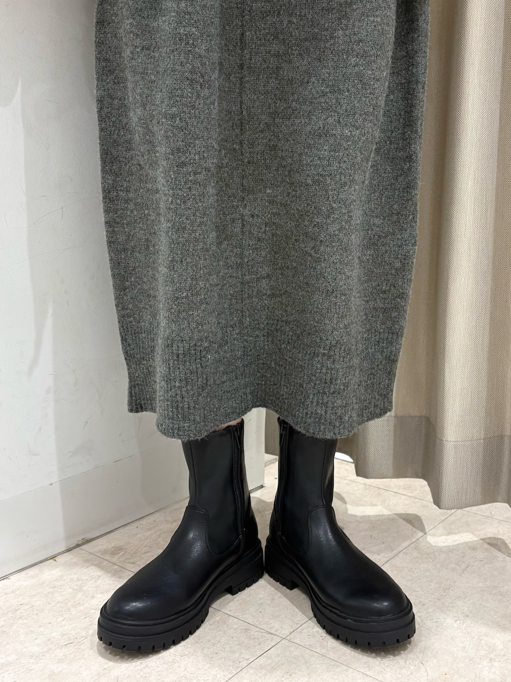 ホワイト系のダウンジャケット/コート、グレー系のワンピース、ブラック系のハンドバッグを着用したレディースの冬コーディネートの4枚目の写真