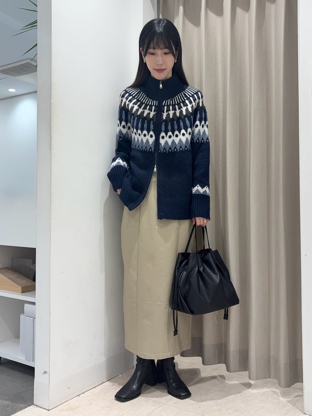 ブラウン系のブルゾン、ブルー系のニット/セーター、ベージュ系のスカートを着用したレディースの冬コーディネートの5枚目の写真