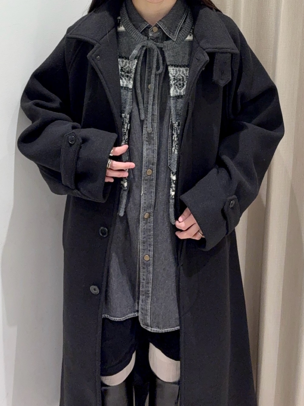 グレー系のベスト、ブラック系のその他アウターを着用したレディースの冬コーディネートの3枚目の写真