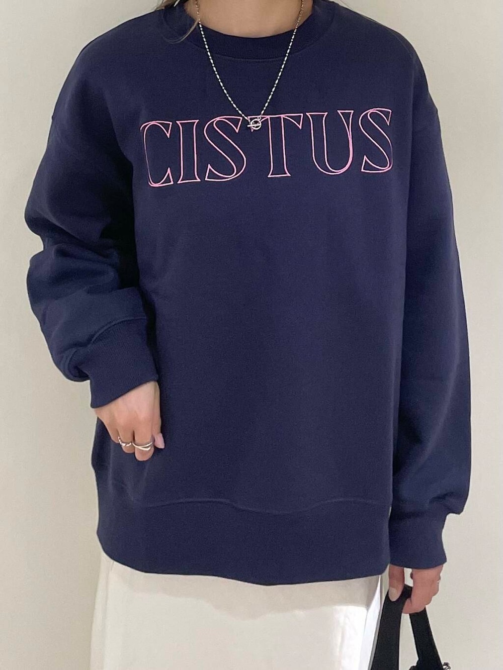 ブラック系のショルダーバッグ、ホワイト系のスカート、その他のスウェットを着用したレディースの秋コーディネートの2枚目の写真