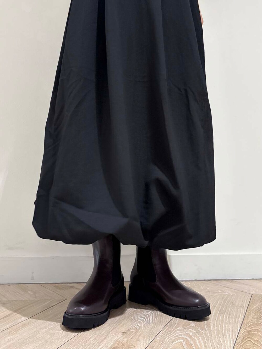 ブラック系のショルダーバッグ、ブラウン系のブーツ、ブラック系のワンピースを着用したレディースの秋コーディネートの4枚目の写真