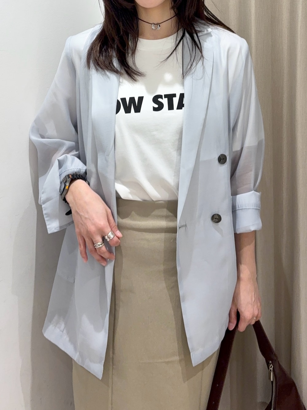 ブルー系のテーラードジャケット、その他のTシャツ/カットソー、ブラウン系のハンドバッグを着用したレディースの春コーディネートの3枚目の写真