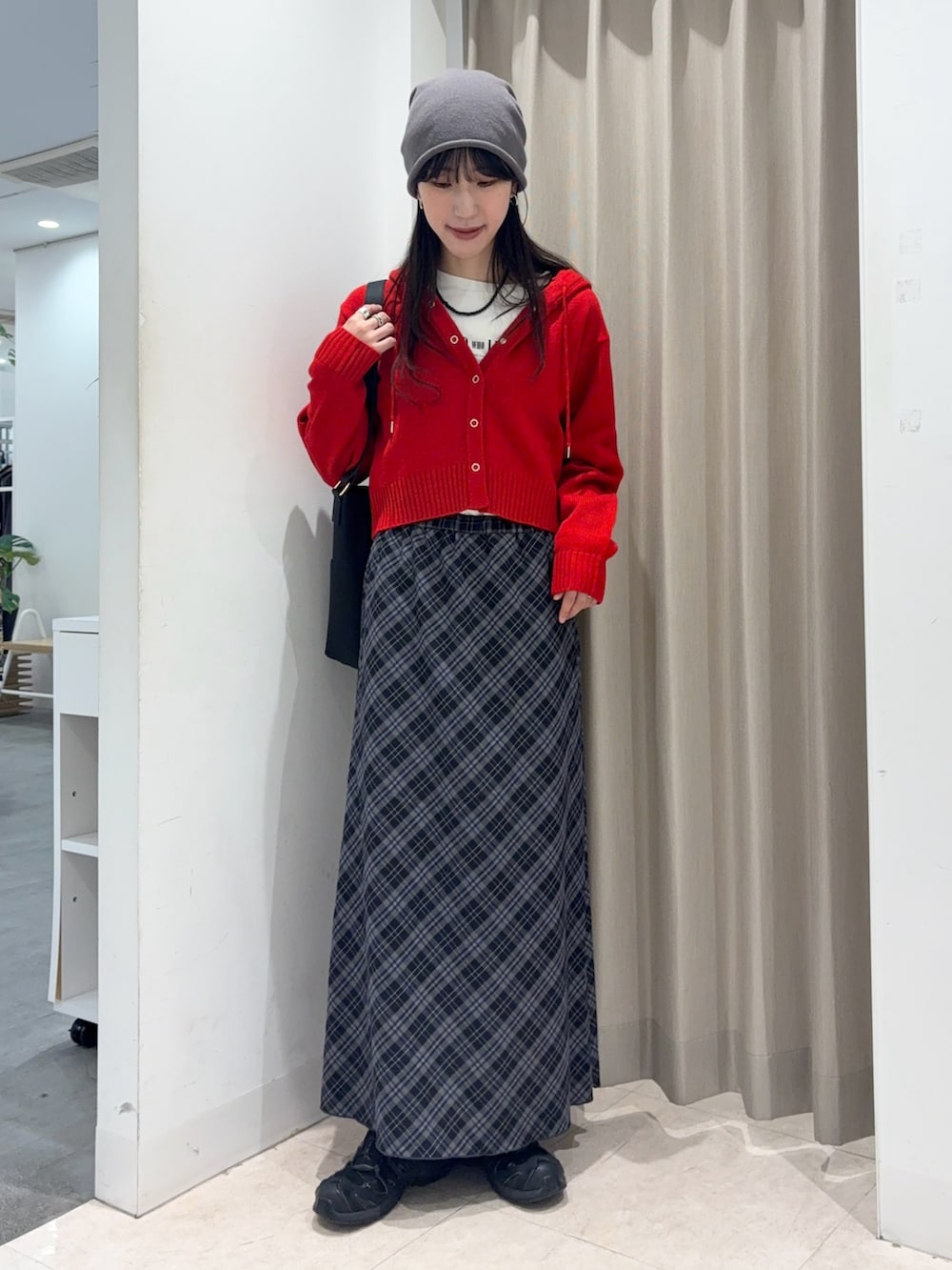 ブルー系のスカート、ホワイト系のTシャツ/カットソー、レッド系のニット/セーターを着用したレディースの秋コーディネートの2枚目の写真