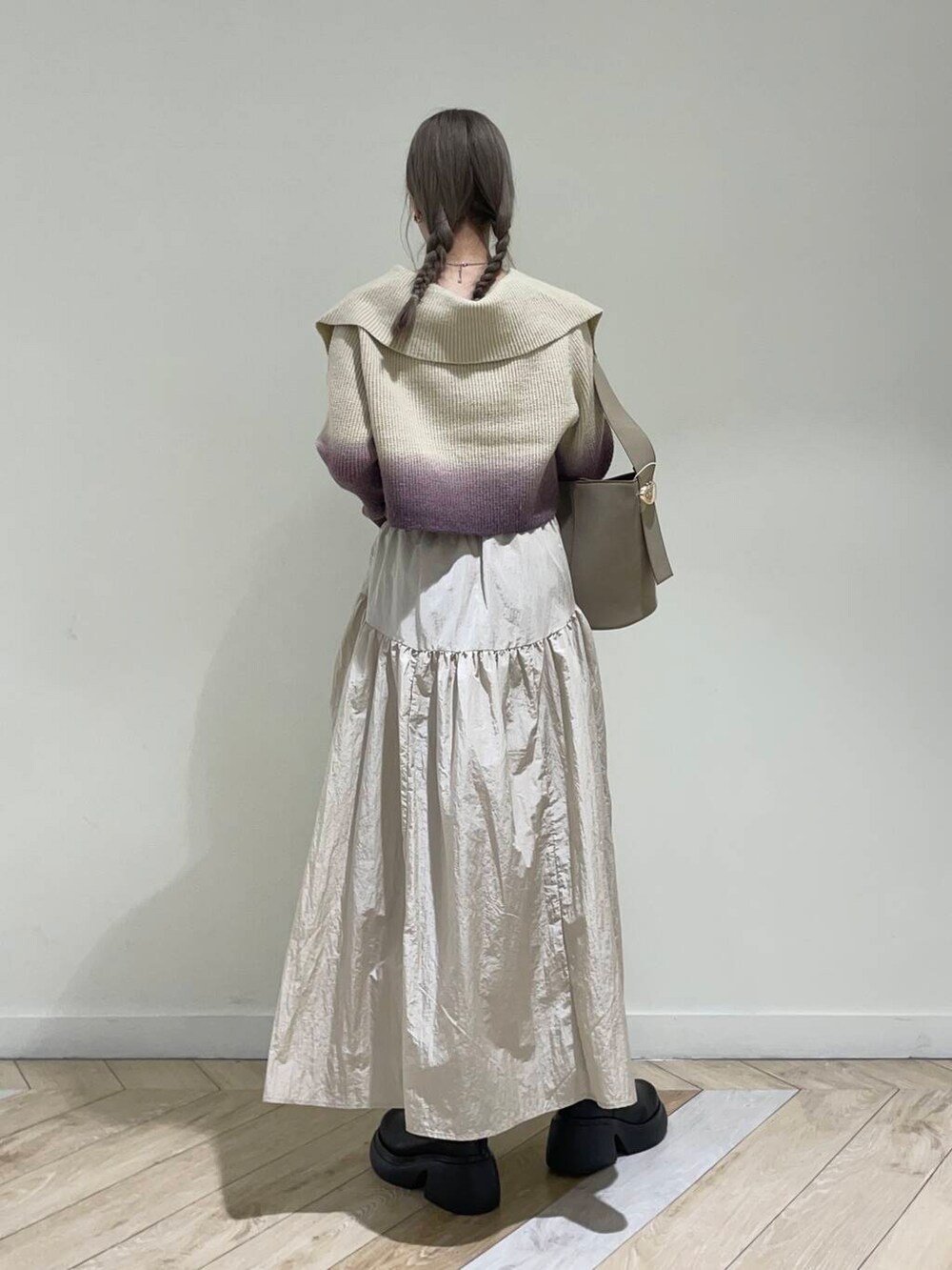 ベージュ系のキャミソール、ブラウン系のニット/セーター、ベージュ系のハンドバッグを着用したレディースの秋コーディネートの3枚目の写真