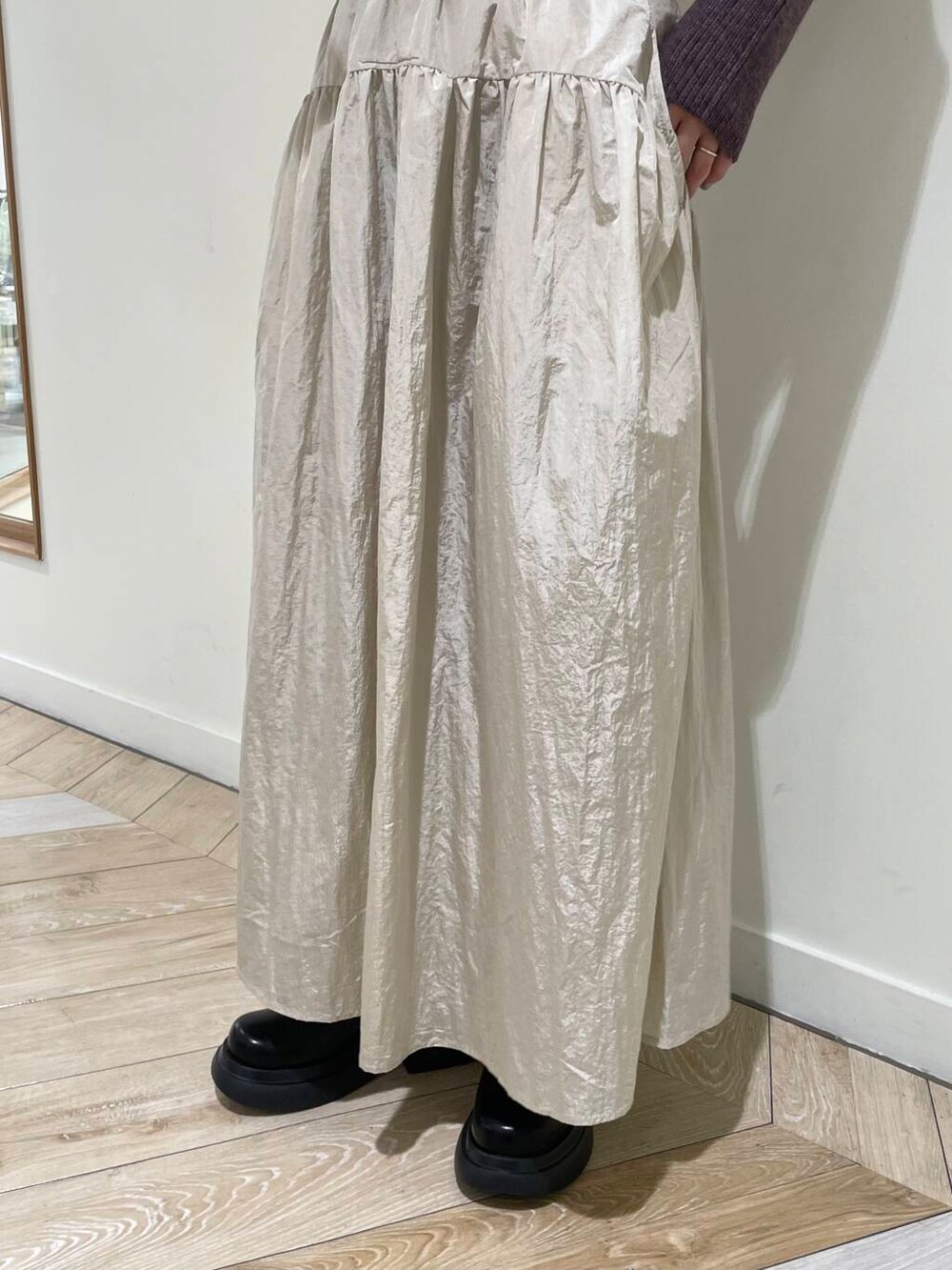 ベージュ系のキャミソール、ブラウン系のニット/セーター、ベージュ系のハンドバッグを着用したレディースの秋コーディネートの5枚目の写真