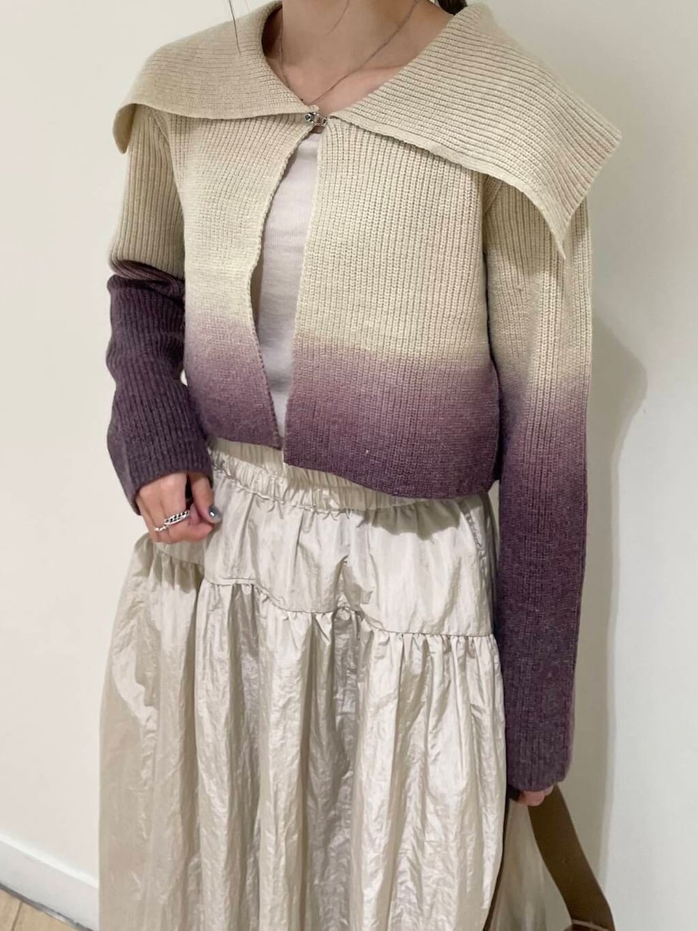 ベージュ系のキャミソール、ブラウン系のニット/セーター、ベージュ系のハンドバッグを着用したレディースの秋コーディネートの4枚目の写真