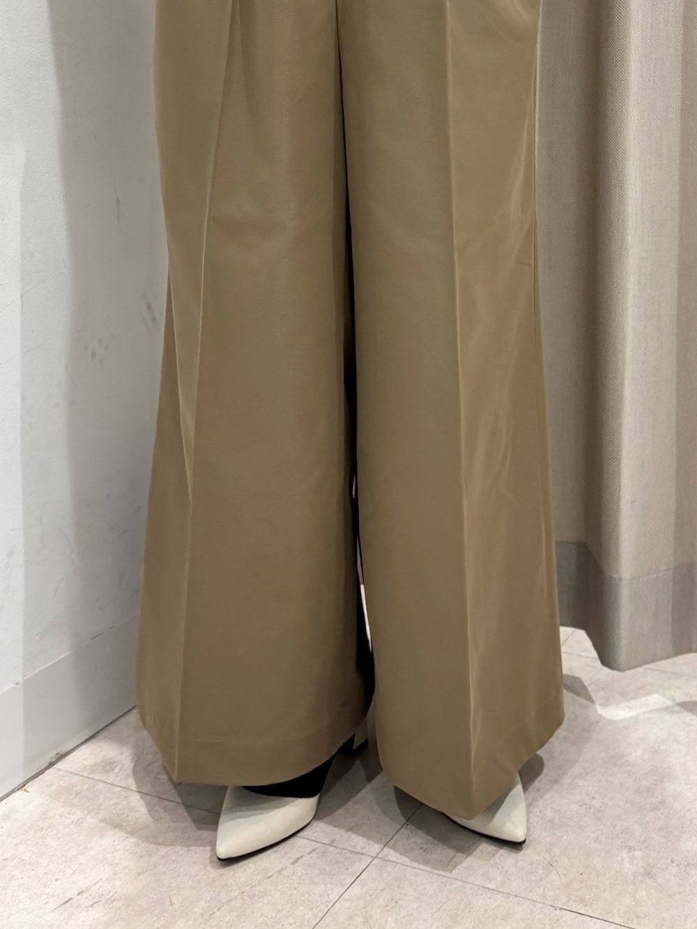 ベージュ系のチノパンツ、ブルー系のシャツ/ブラウス、ベージュ系のトレンチコートを着用したレディースの春コーディネートの3枚目の写真