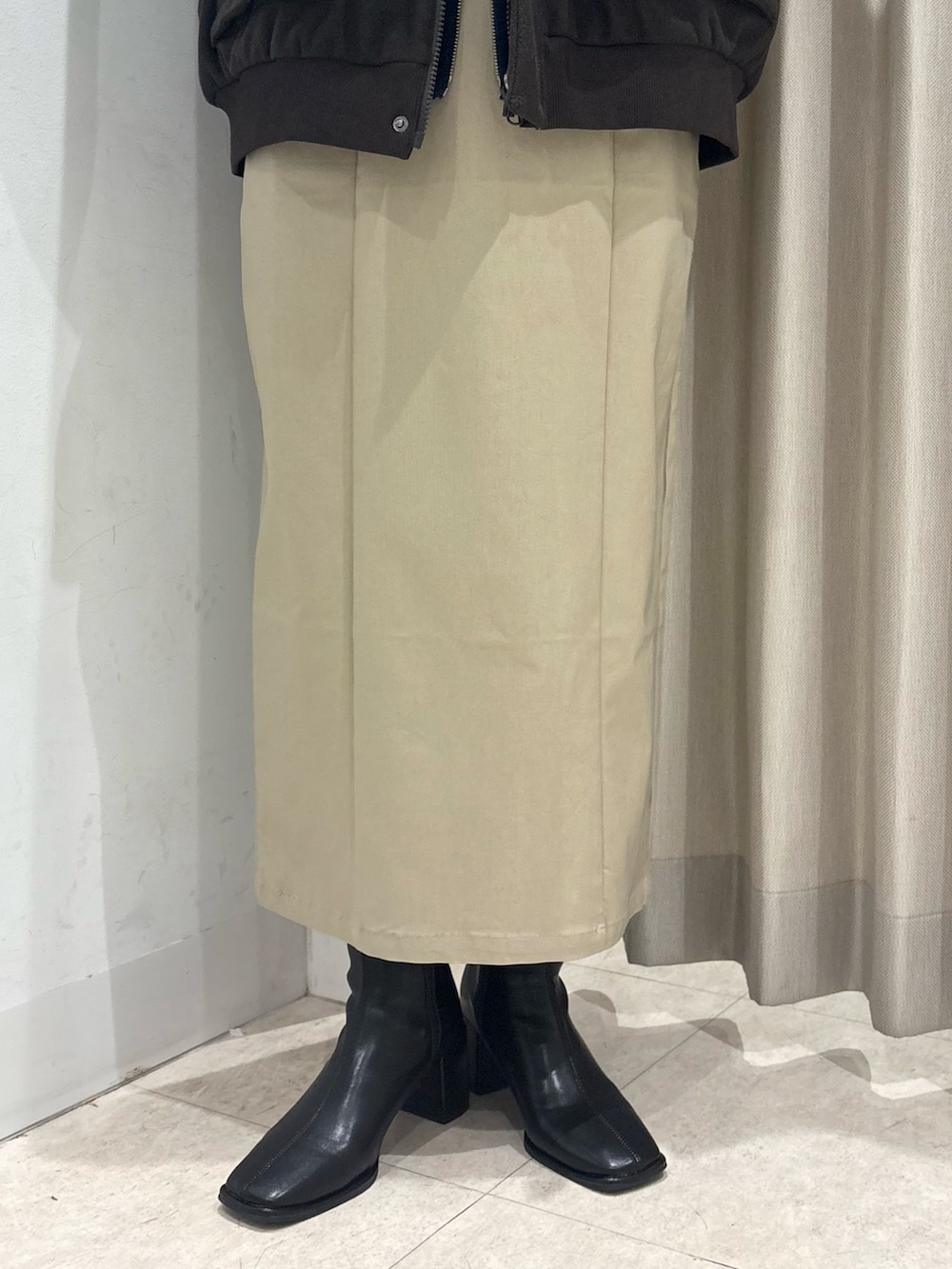 ブラウン系のブルゾン、ブルー系のニット/セーター、ベージュ系のスカートを着用したレディースの冬コーディネートの4枚目の写真