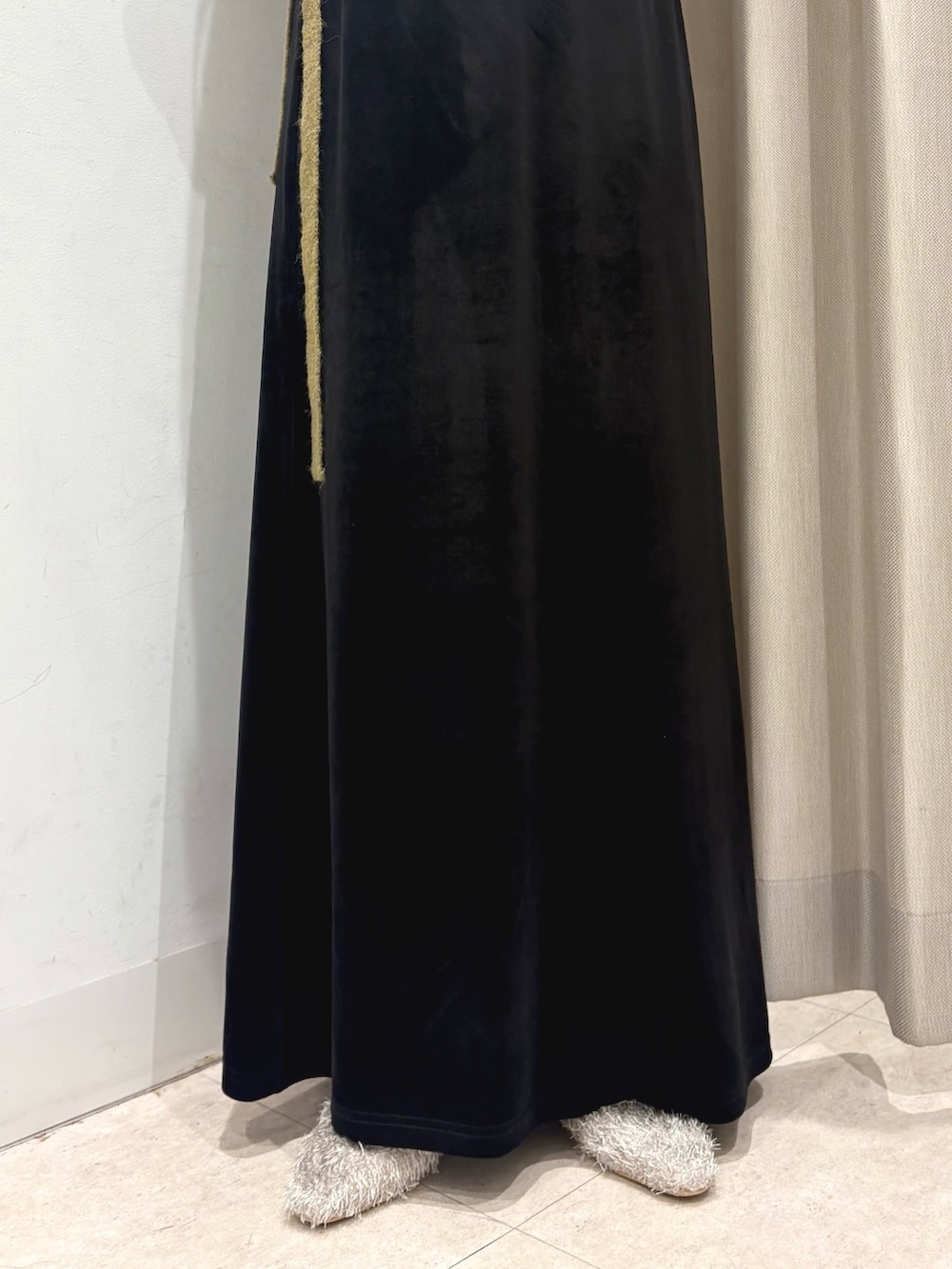 グリーン系のニット/セーター、ホワイト系のキャミソール、ブラウン系のスカートを着用したレディースの秋コーディネートの4枚目の写真