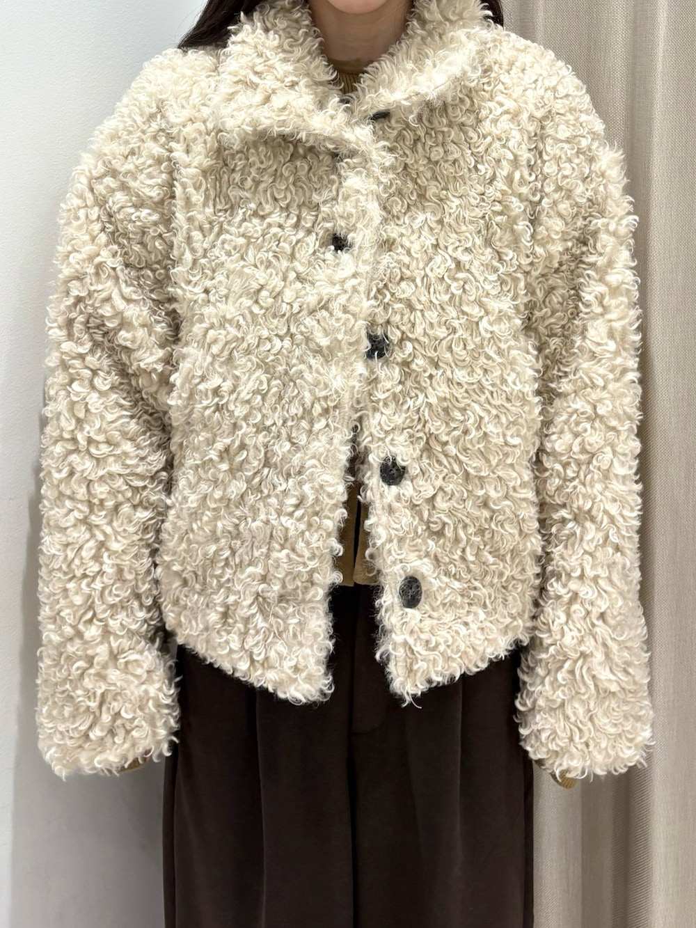 ホワイト系のその他アウター、ベージュ系のニット/セーター、ブラウン系のその他パンツを着用したレディースの冬コーディネートの2枚目の写真